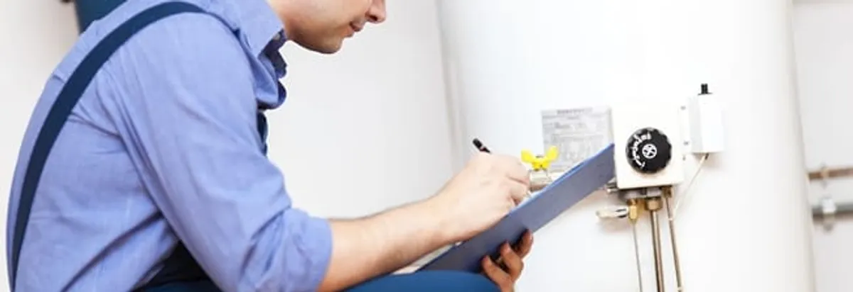 Water heater repair technician inspecting the unit and recording service notes in Eugene, OR